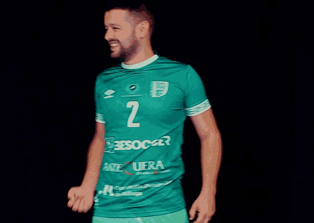 a man wearing a green shirt with the number 2 on the front