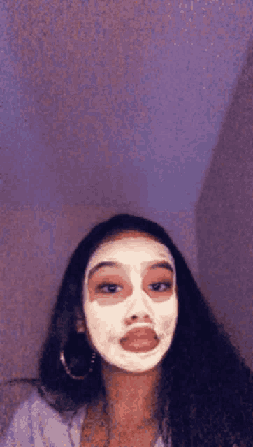 a woman is wearing a white mask on her face