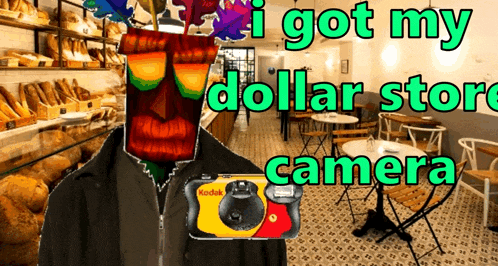 a man in a black jacket holding a kodak camera in front of a bakery