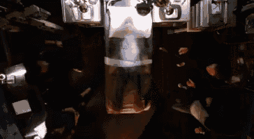 a man is laying in a glass container in a room