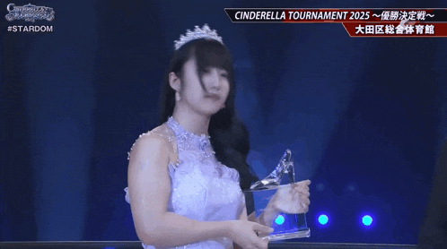 a woman in a white dress and tiara is holding a trophy in front of a sign that says cinderella tournament 2025