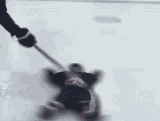 a hockey player is laying on the ice and holding a stick