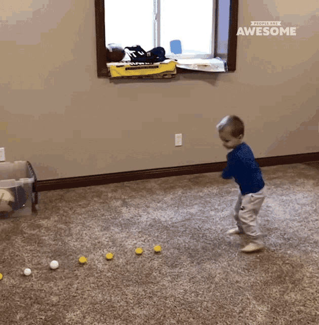 a little boy playing with golf balls in a room that says awesome on the wall