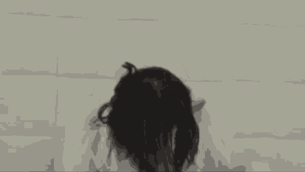 a woman in a white robe is sitting in front of a wall .