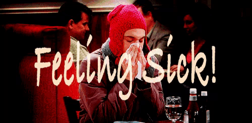 a man in a red hat is blowing his nose in front of a sign that says " feeling sick "