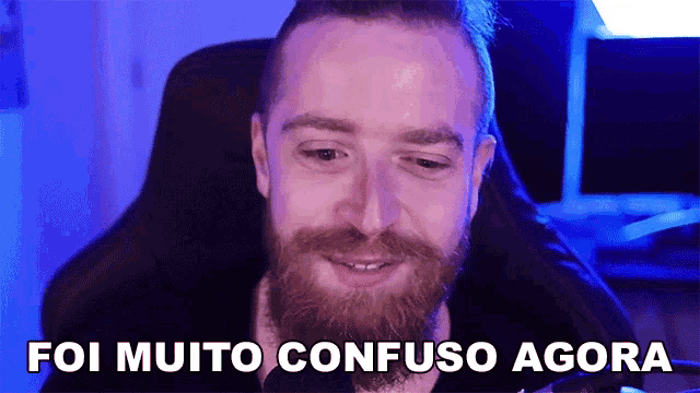 a man with a beard is sitting in a chair with the words foi muito confuso agora below him