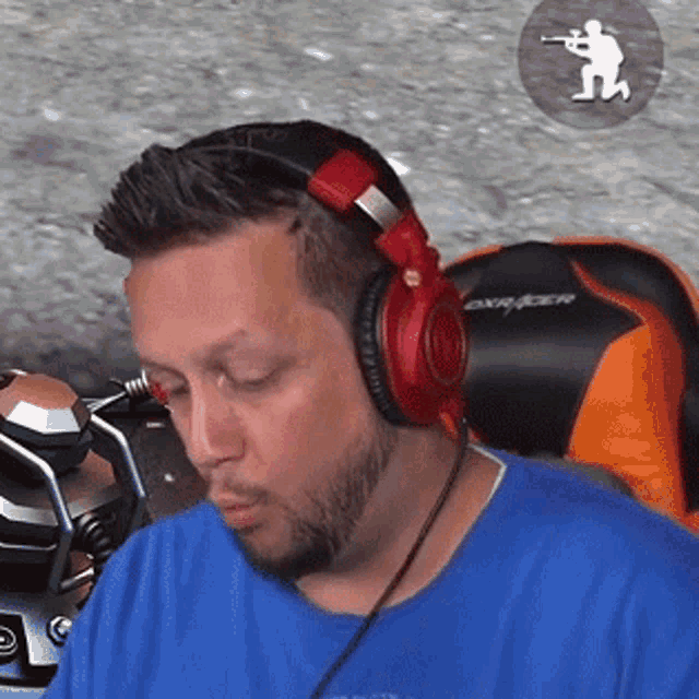 a man wearing headphones is sitting in an orange chair