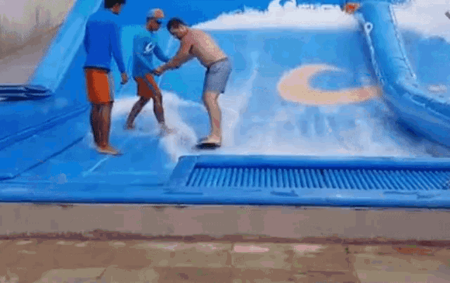 a man is riding a wave on a surfboard in a water slide .