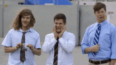 three men in ties are standing next to each other and one of them is making a funny face .