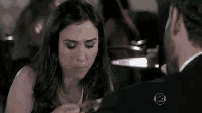 a man and a woman are sitting at a table eating food .
