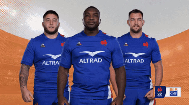 three men wearing blue shirts with altrad on the front