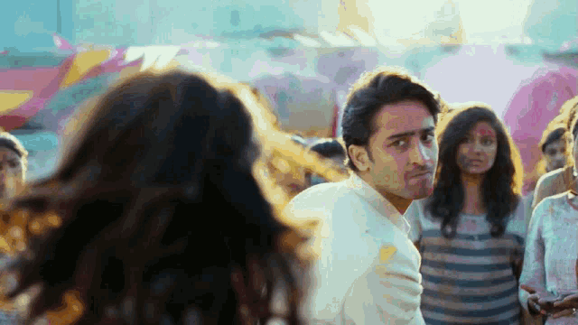 a man in a white shirt is looking at a woman
