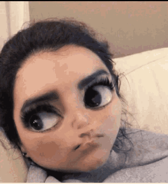 a woman with big eyes is laying on a couch and making a cartoon face .