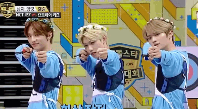 a group of young men are pointing their fingers at the camera while wearing flower crowns
