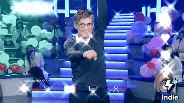 a man is dancing in front of a crowd and the word indie is on the screen