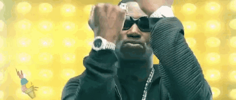 a man wearing sunglasses and a watch is making a fist .