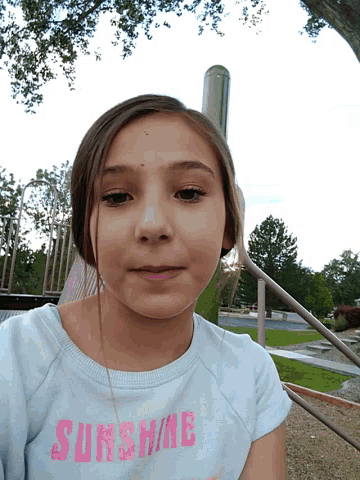 a little girl wearing a shirt that says sunshine on it