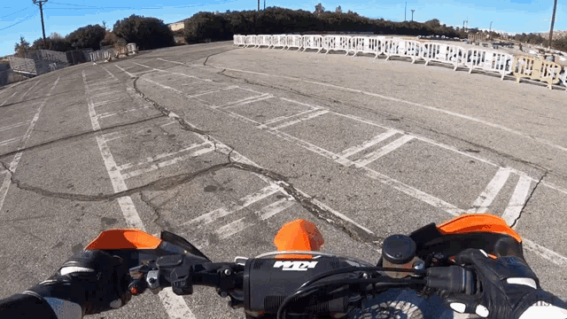 a person riding a dirt bike with a ktm logo on the handlebars