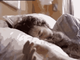 a man is sleeping in a bed with a dog