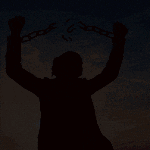 a silhouette of a man holding chains with the letter u written on them