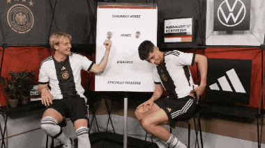 two soccer players are sitting in front of a white board that says ' strictly agree ' on it