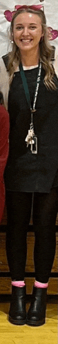 a woman wearing a black dress and pink socks is smiling .