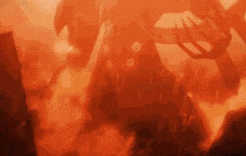 a person is standing in the middle of a fire with a sword .