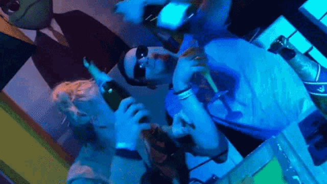 a man in sunglasses holds a bottle of champagne