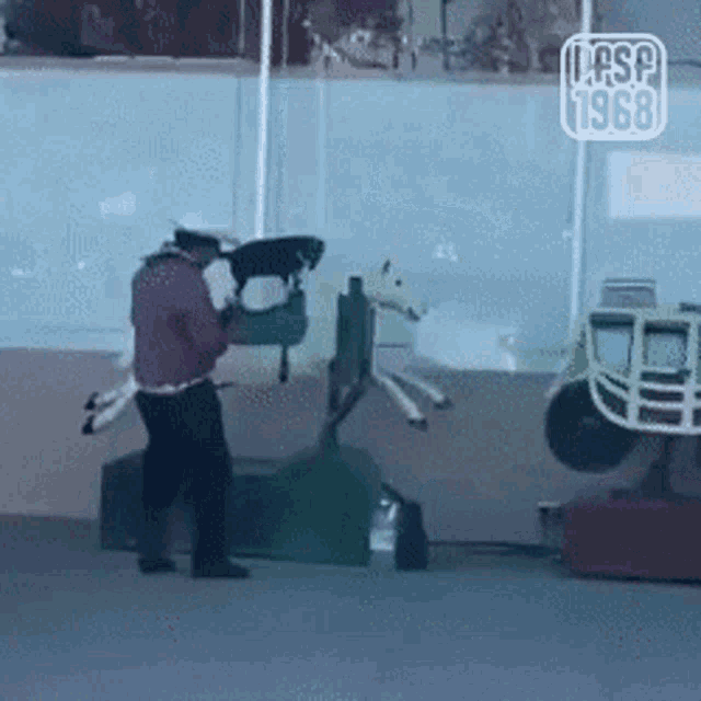 a man is standing next to a rocking horse and the year 1968 is on the bottom