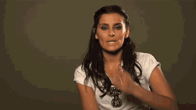 a woman covering her mouth with her hand and wearing a ring