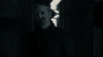 a man and a woman are standing next to each other in the dark .