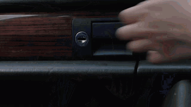 a person is taking a gun out of the glove box