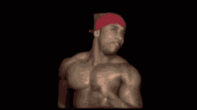 a man with a red hat on his head is standing in a dark room .