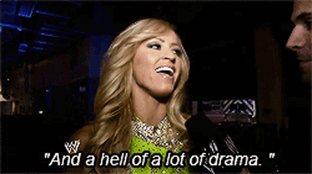 a woman says " and a hell of a lot of drama " in front of a microphone