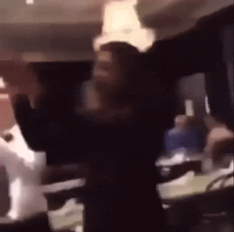 a blurry picture of a person dancing in a room with a chandelier .