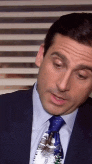 a man in a suit and tie is making a funny face .