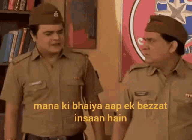 a couple of police officers standing next to each other in a room .