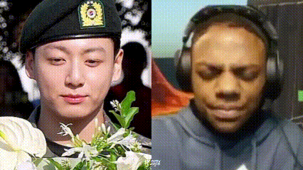 a man in a military uniform is holding a bouquet of flowers and a man wearing headphones is sitting down .