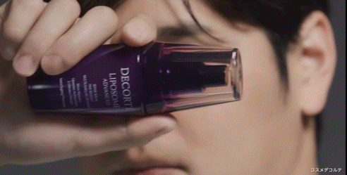 a close up of a man holding a bottle of decorte liposome advanced