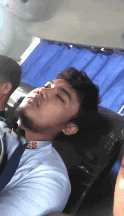 a man sleeping in a car with the letter ss on his shirt