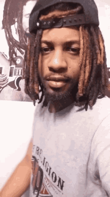 a man with dreadlocks wearing a religion shirt