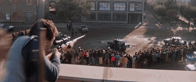 a man is aiming a rifle at a crowd of people in front of a building that says ' super populaire '