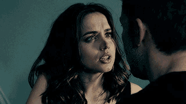 a man and a woman are looking at each other and the woman is wearing a black top