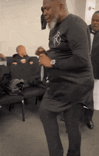 a man in a black shirt with the letter x on it is dancing