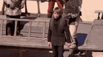 a group of people standing next to each other on a boat .