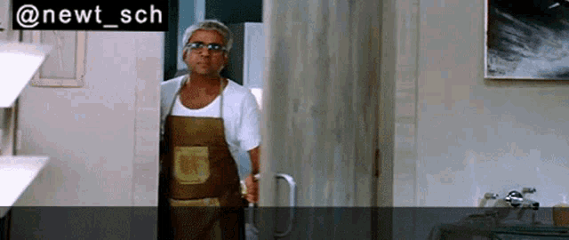 a man in an apron is standing in front of a door with the hashtag @newt_sch on it