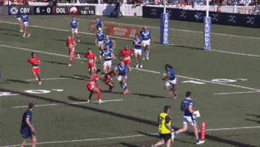 a rugby player in a blue and white jersey is running with the ball .