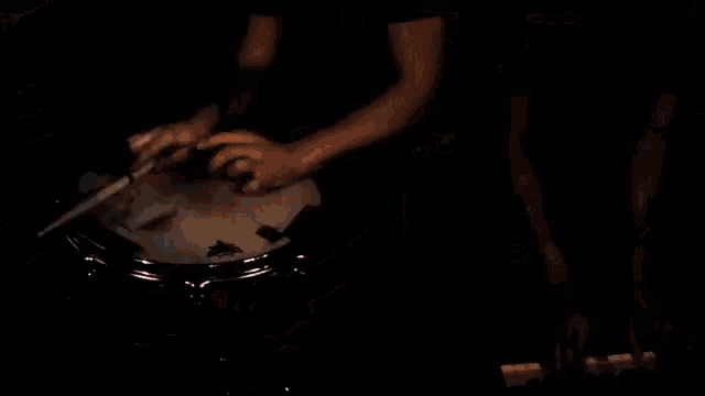 a man with a bandana on his head is playing a guitar in a dark room