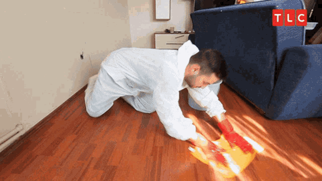 a man cleaning a wood floor with a tlc logo in the background
