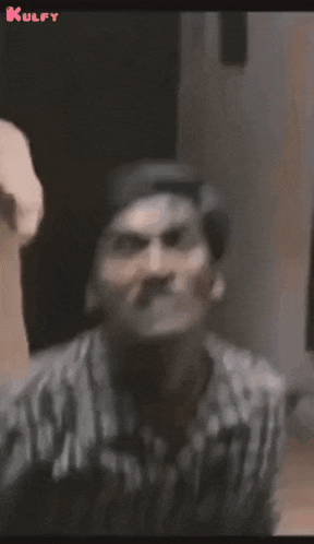 a man in a plaid shirt is making a funny face in a black and white photo